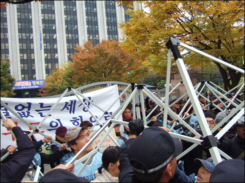 경찰이 천막 뼈대를 철거하고 있다. 